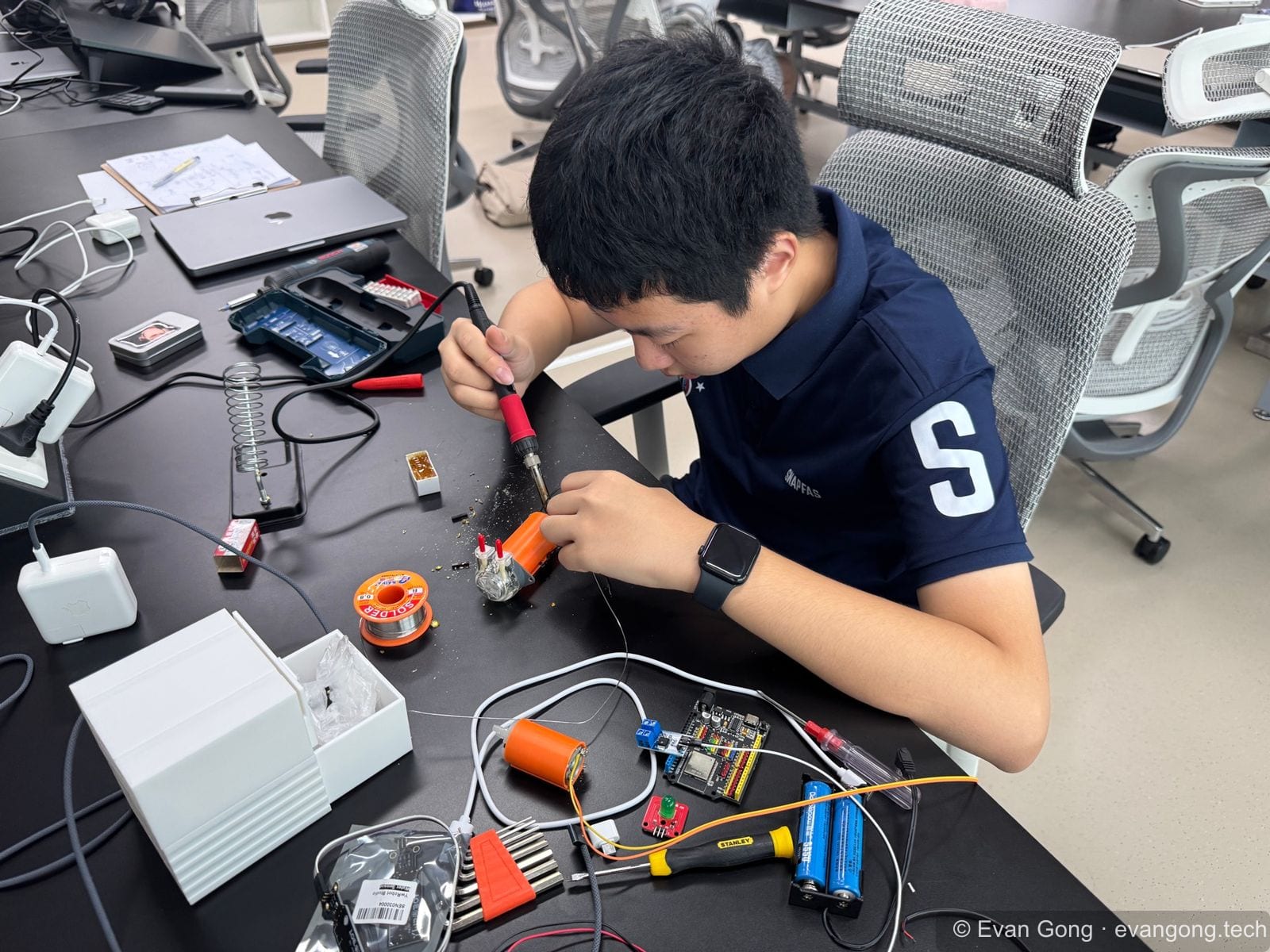 Gong Yifan soldering electronics for the BASIS-China iGEM hardware system